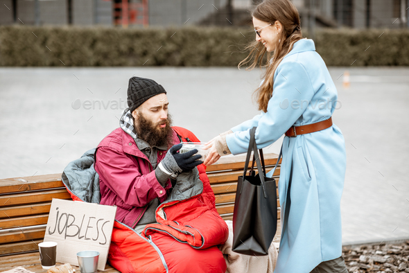 Woman giving food to a homeless beggar
