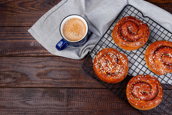 Traditional freshly baked Swedish cinnamon buns Kanelbulle with cup of coffee, copy space, top view - Stock Photo - Images
