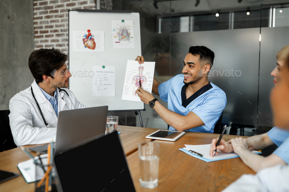 Positive middle-eastern man chief doctor making presentation for colleagues