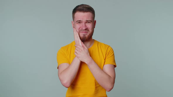 Man Touching Cheek Suffering From Toothache Cavities or Gingivitis Waiting for Dentist Appointment alt