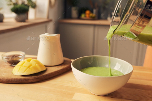 Electric blender with vegetable smoothie on kitchen table Stock Photo by  Pressmaster