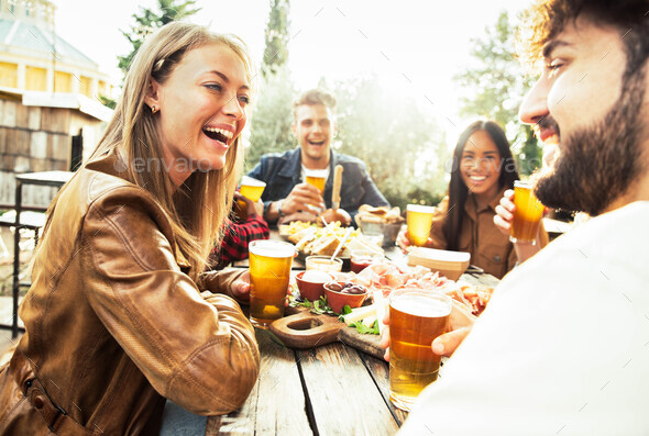 Happy mixed race family having dinner together outdoor - Stock Photo - Images