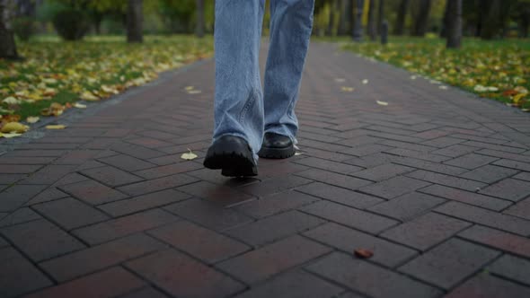 Close Up Unknown Female Walking in Boots and Jeans in Autumn Park alt