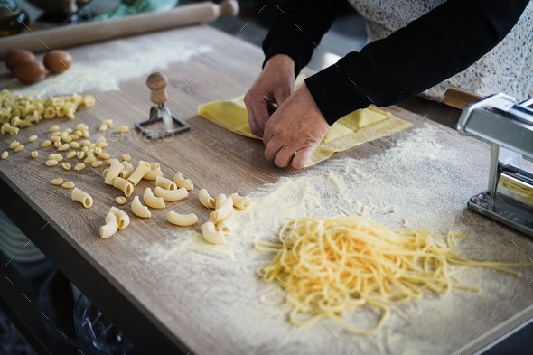 Woman prepare fresh ravioli inside pasta factory