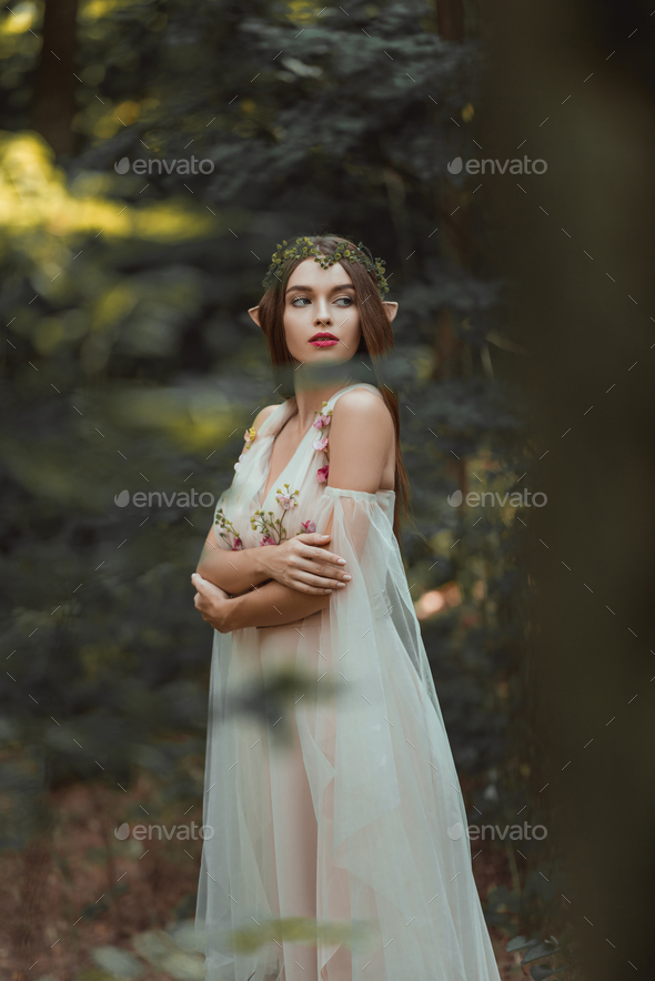 attractive girl with elf ears walking in fantasy forest