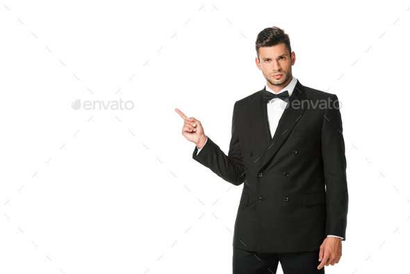 handsome young man in suit pointing at blank space isolated on white