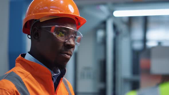 Man Engineer Shaking Head Wearing Safety Uniform at Modern Factory Closeup alt