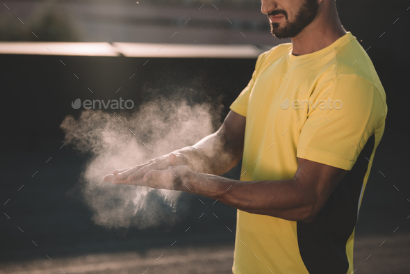 cropped image of sportsman clapping hands with talc powder on roof