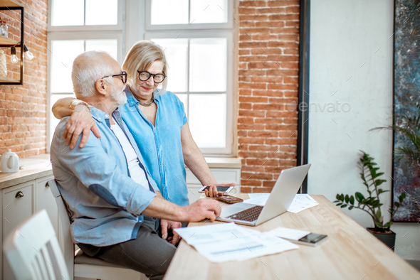 Senior couple with laptop at home - Stock Photo - Images