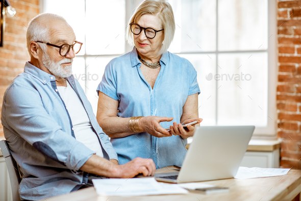 Senior couple with laptop at home - Stock Photo - Images