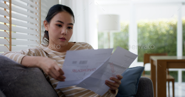 Upset tired young asia sad lady people sit sofa couch at home think hard worry