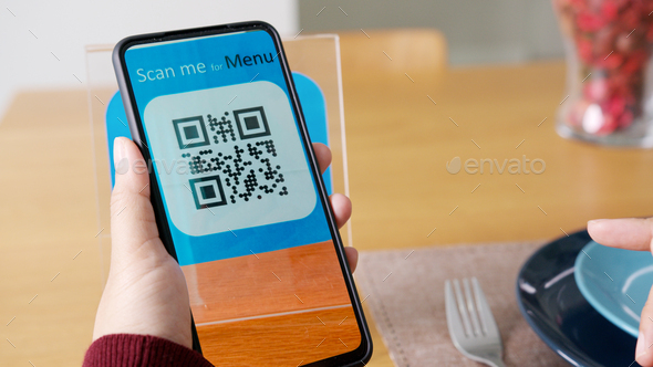 Hand\'s customer scan QR code for online menu service at table in restauran