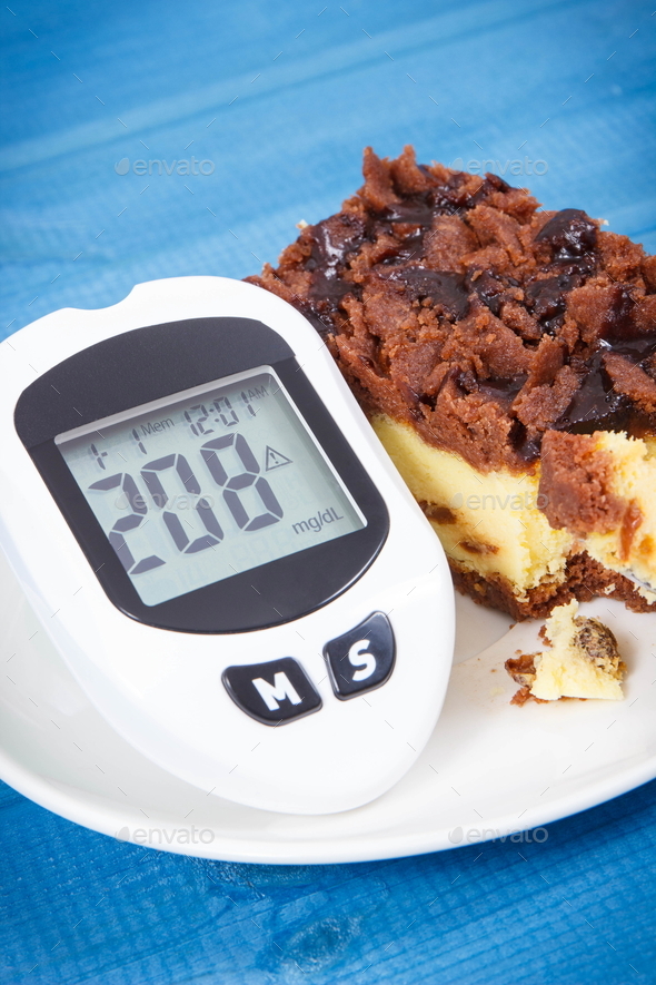 Glucose meter with high and bad result sugar level and fresh baked homemade cheesecake
