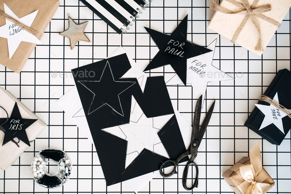 Personalized gifts. Modern black and white flat lay with Christmas gift wrapping process. Scissors