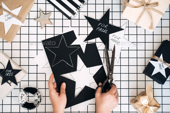 Personalized gifts. Modern black and white flat lay with Christmas gift wrapping process. Female