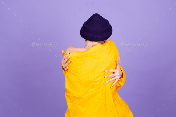 Stylish european woman on purple background self care hugging herself with smile and closed eyes