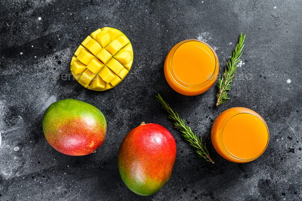 Freshly squeezed mango juice in a glass. Black background. Top view Stock  Photo by composter-box