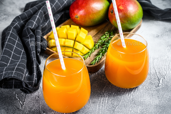 Refreshing mango juice in a glass. Gray background. Top view Stock Photo by  composter-box