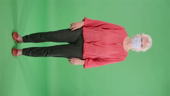 Portrait Elderly Woman Looking at the Camera and Removing the Medical Mask alt