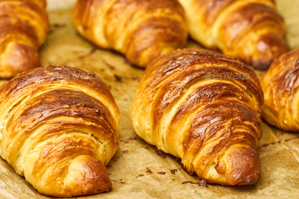 Puff pastry croissants with chocolate on baking sheet. Homemade cooking ...