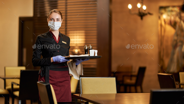 Lady in a mask tables at a fancy restaurant - Stock Photo - Images