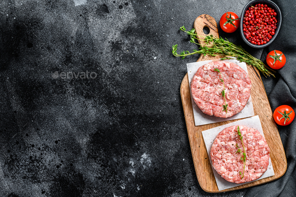 Raw chicken patty, ground meat cutlets on a chopping Board. Organic mince.