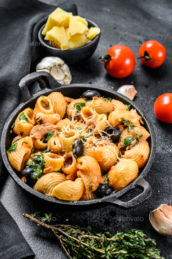 Traditional italian pasta with tomato, olives, capers, anchovies. Conchiglie rigate, puttanesca