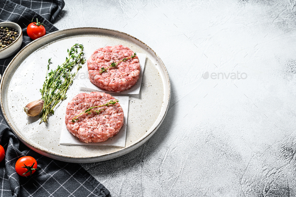 Raw chicken cutlets, ground meat patty. Organic mince. White background. Top view. Copy space