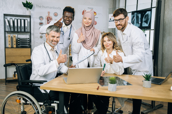 Multiracial medical workers showing thumbs up on camera - Stock Photo - Images