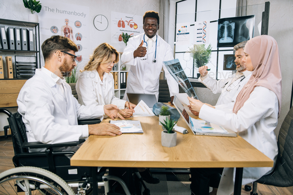 Team of five diverse medical workers having meeting at office - Stock Photo - Images