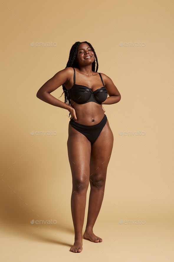 African American woman with braids in lingerie against yellow