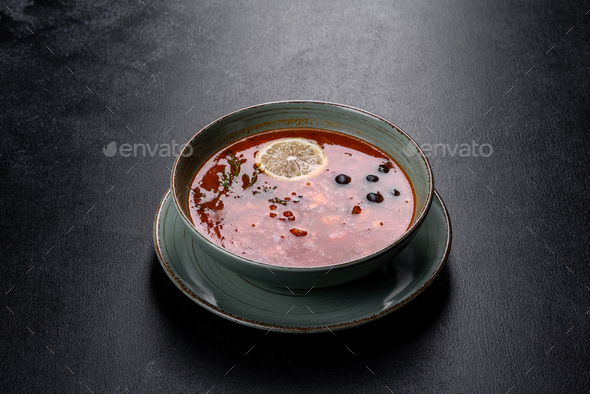 Delicious fresh hot soup with tomato and meat in a ceramic plate