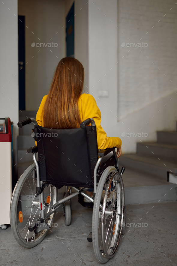Disabled female student in wheelchair at stairs - Stock Photo - Images