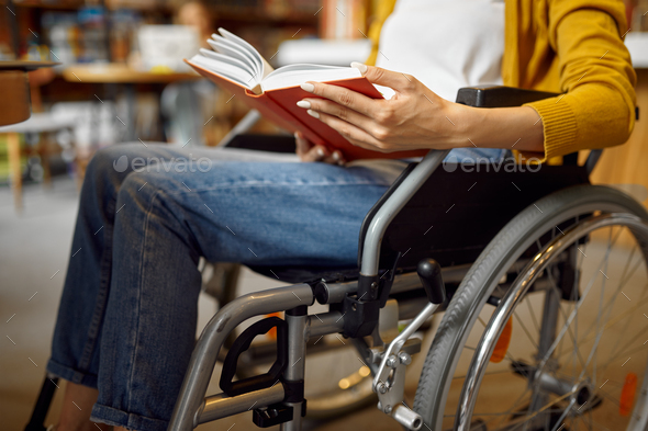 Disabled student in wheelchair reading a book - Stock Photo - Images