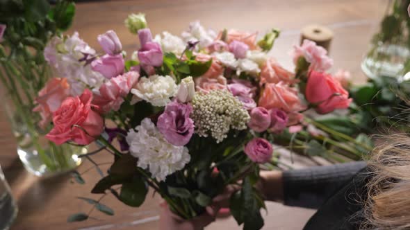 Florist Woman Arranges Fresh Spring Bouquet in Flowershop alt