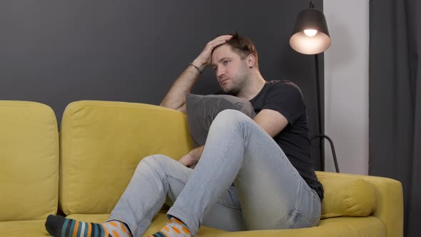 Depressed Unshaven Guy Suffering From Depression on Sofa