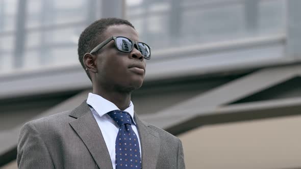 Successful African American business man looks at the horizon success in business alt