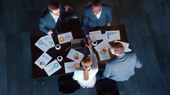 A group of people arriving for a business meeting and greeting each other alt