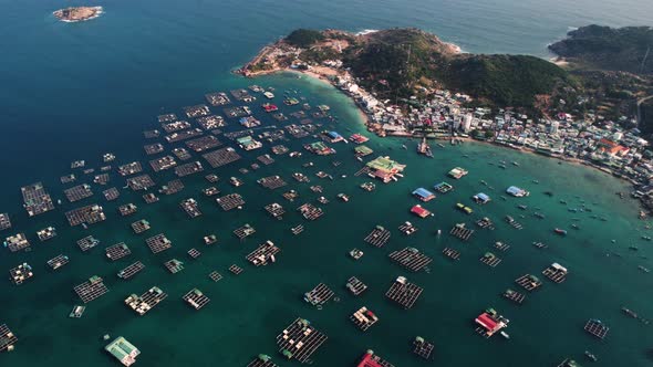 Aerial, floating fish farms on tropical ocean island coast in Southeast Asia alt