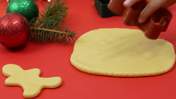 Christmas baking, little girl sculpts festive Christmas gingerbread cookies.