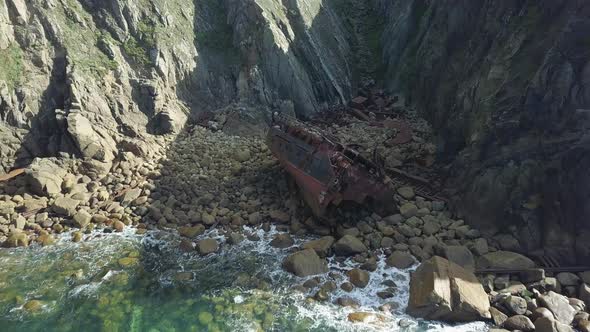 Waves Splashing On The Rocky Coast With RMS Mulheim Shipwreck Near Land's End In Cornwall, UK - pull alt