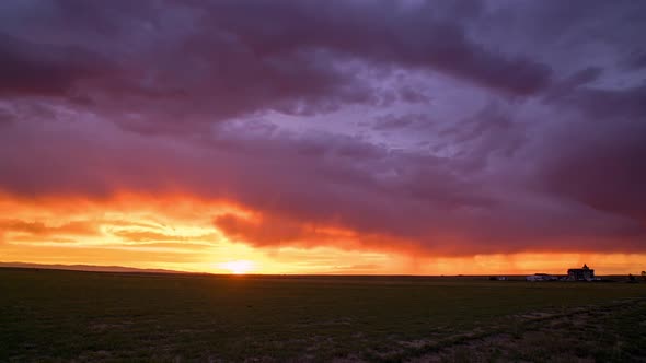 Colorful sunset timelapse with farmhouse over the flat plains alt