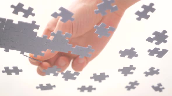Bottom View. Human Hands Assembling Jigsaw Puzzle. Pastime, a Hobby. Complex Project Management