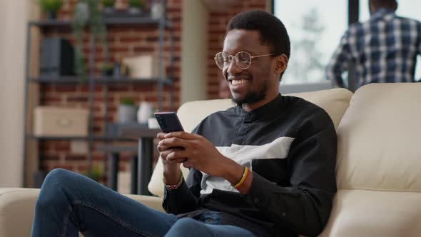 African American Man Browsing Internet on Smartphone alt