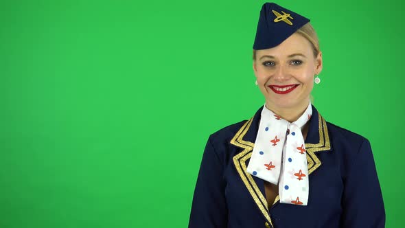A Young Beautiful Stewardess Smiles at the Camera - Green Screen Studio alt