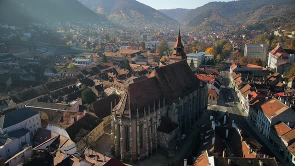 Aerial drone view of The Black Church in Brasov, Romania. Old city centre with buildings and people alt