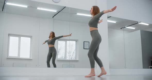 Dancer Woman Jumps in Slow Motion Infront of Mirror Wall Gymnastics in the White Dance Hall alt