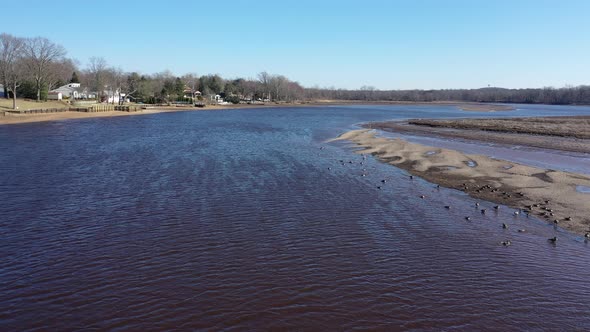 ‎⁨A low angle view over Rancocas Creek in NJ on a bright & sunny day. The drone camera hovers, pan l alt
