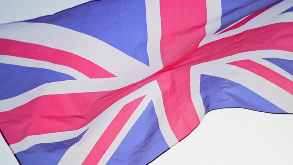 The Flag of Great Britain Develops in the Wind at Sunset Against the Sky. Slow Motion, National