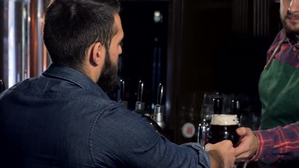 Unrecognizable Man Drinking Delicious Craft Beer at the Pub alt